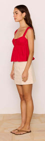 Model wearing a Red Cotton Linen Blend Tie-Front Top with a beige mini skirt, showcasing a chic summer look.