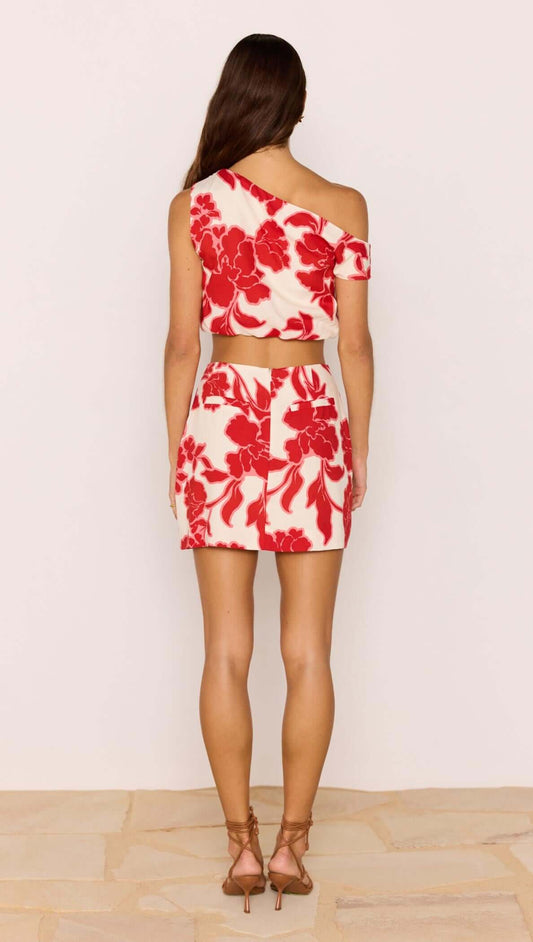 Back view of a model wearing a Red & White Floral Linen Blend Mini Skirt paired with a matching top.